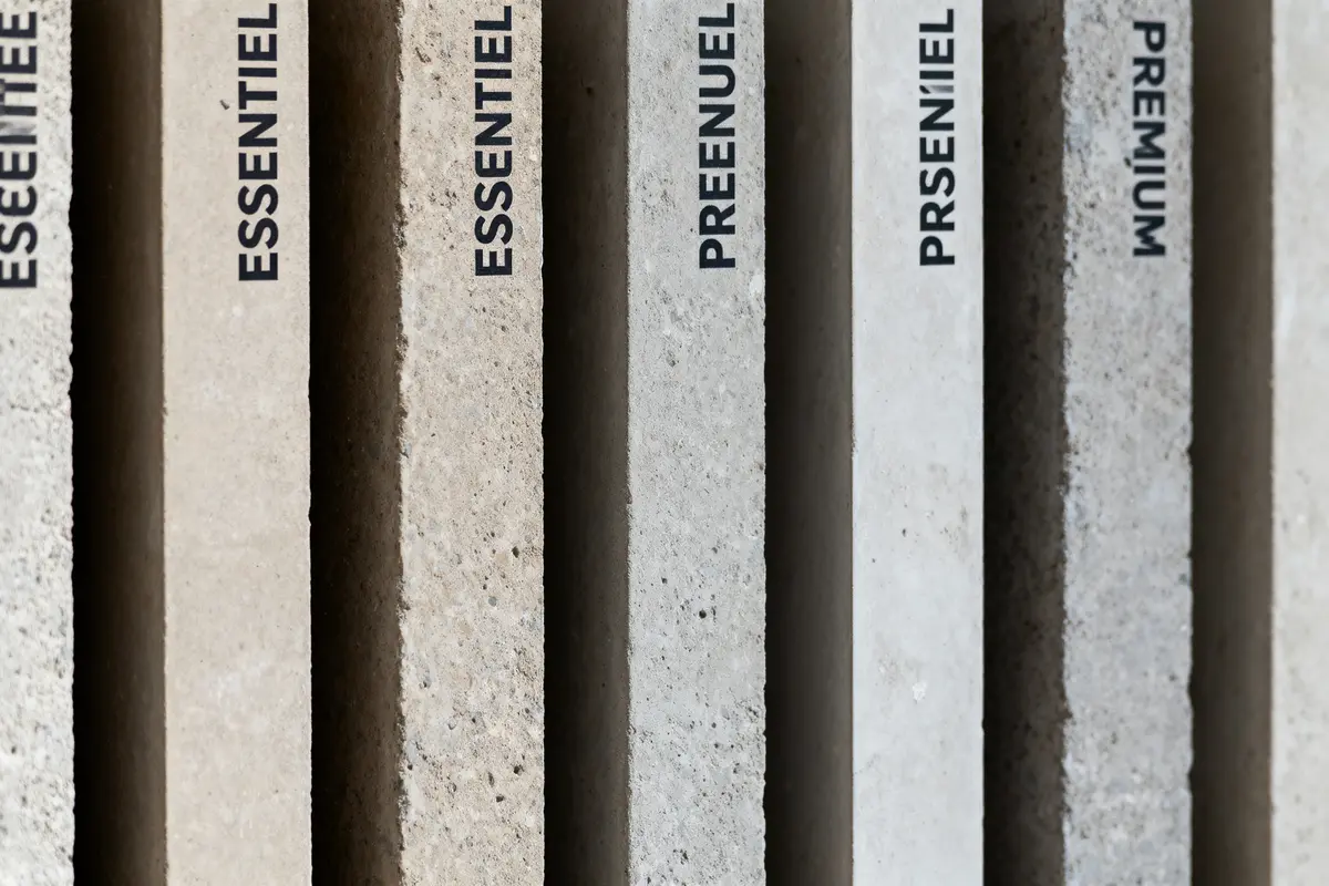 Plaques verticales de béton avec inscriptions : Essentiel, Preenuel, Prseniel, Premium, textures et couleurs variées.