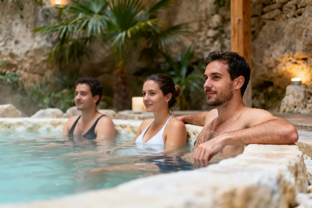 Personnes profitant d'un moment relaxant dans un bain thermal body and spa extérieur