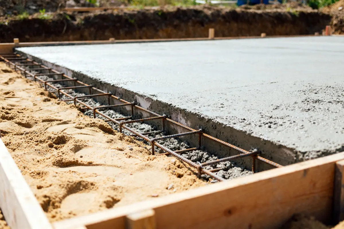 Construction d'une dalle béton avec armature métallique et coffrage en bois sur chantier