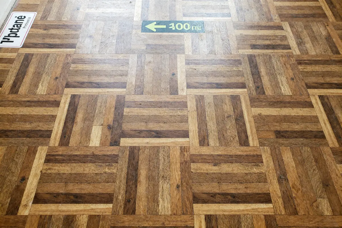 Sol avec motif carré et flèche sur balatum imitation parquet